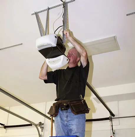 A technician working on a garage door opener, illustrating the quality of service provided.