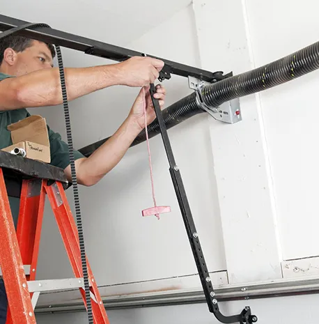 A technician working on a garage door, illustrating the benefits of choosing their installation service.