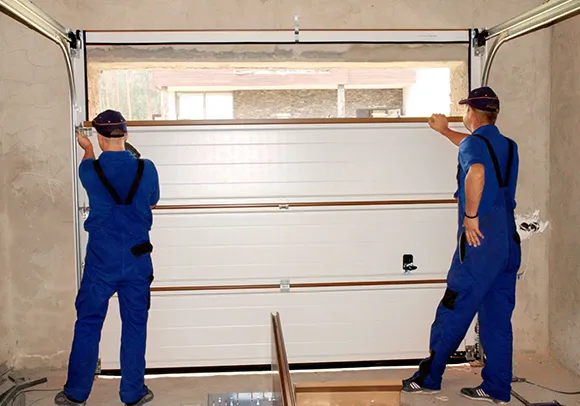 Two technicians repairing a garage door in Rocklin, CA, illustrating professional garage door repair.