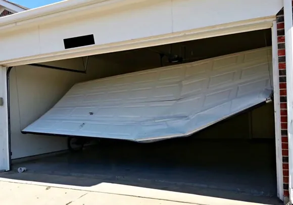 A broken garage door on a house in Lincoln, CA, emphasizing trusted urgent garage door service.